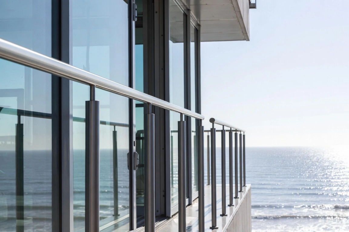 Brushed stainless-steel railing on a glass facade in a seaside setting